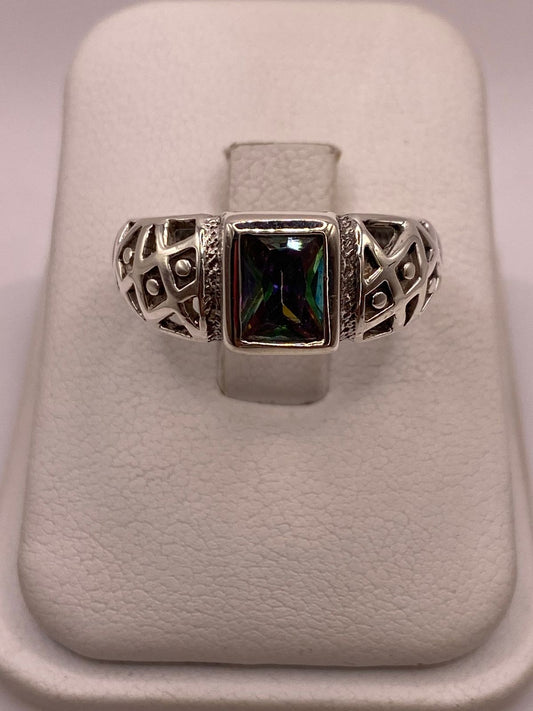 Anillo solitario de plata .950 con circonia rectangular multicolor y calado geométrico sobre fondo neutro — artesanal Taxco