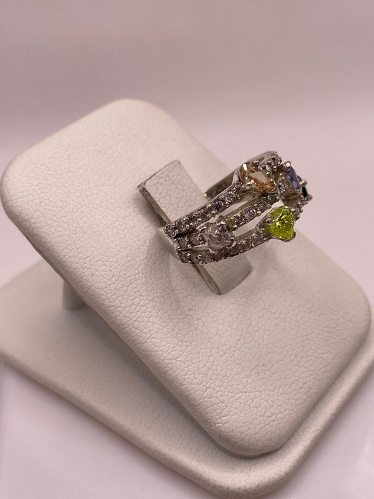 Anillo de plata .925 con circonias amarilla, azul y blanca, en la mano con uñas rosa