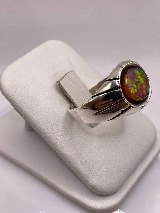 Detalle lateral del anillo mostrando las bandas pulidas y el juego de color del ópalo