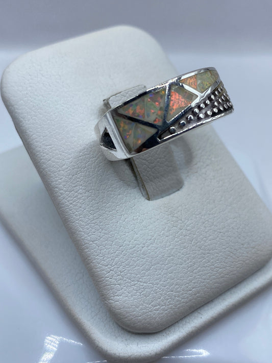 Vista frontal del anillo unisex geométrico con piedra de fuego en posición vertical