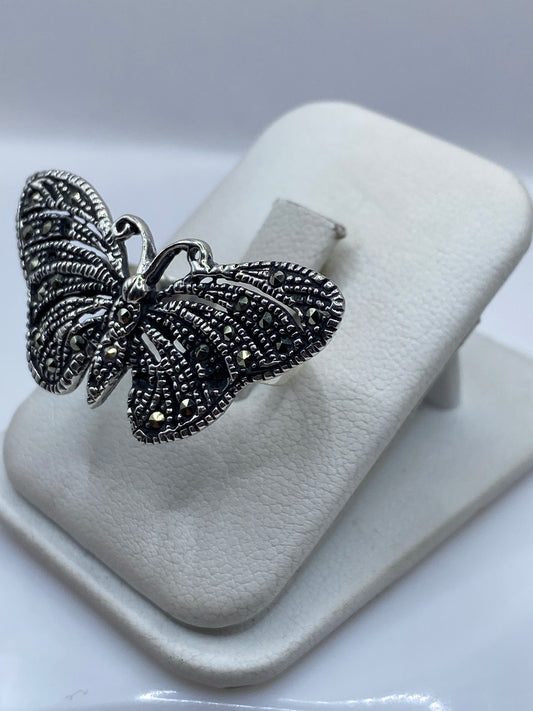 Vista frontal del anillo mariposa artesanal mostrando las alas labradas en Taxco