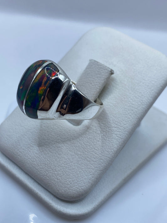 Detalle lateral del anillo mostrando el juego de colores rojo, azul y verde del ópalo de fuego