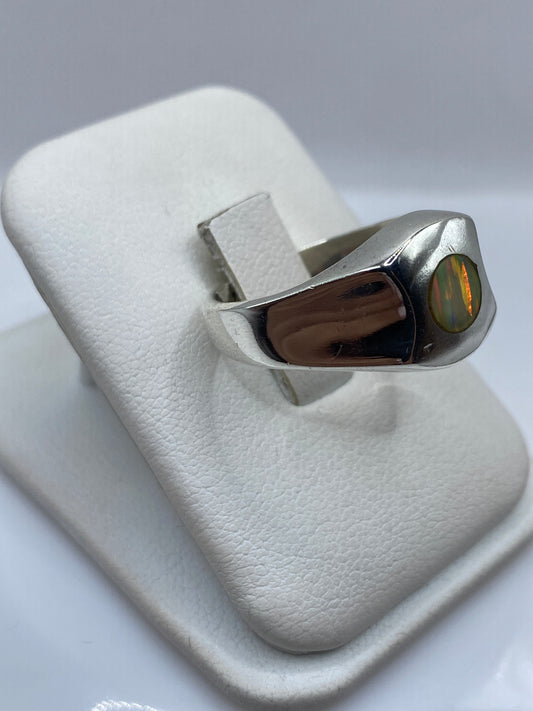 Anillo escultural de plata con ópalo de fuego mostrando juego de rojo y verde desde el lateral