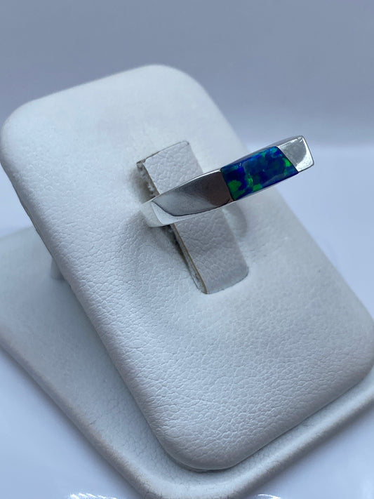Vista lateral del anillo minimalista de plata pura con ópalo natural