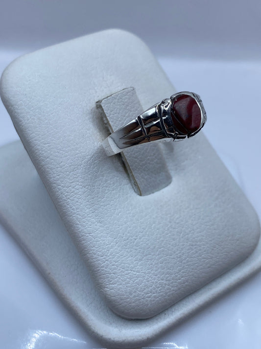 Vista lateral del anillo minimalista con coral rojo pulido y engaste de plata .925