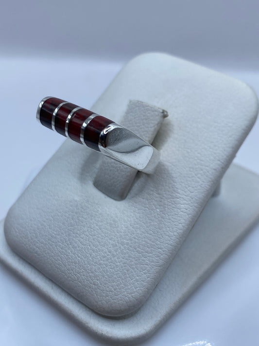 Vista frontal del anillo de coral rojo con banda de plata pulida