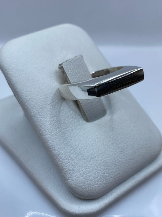 Vista lateral del anillo minimalista en plata pulida mostrando el engaste central