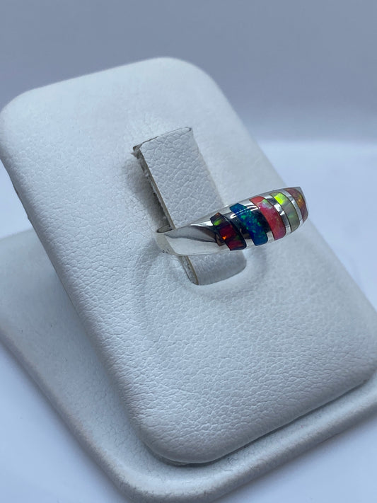 Vista frontal del anillo minimalista mostrando el juego de fuego del ópalo