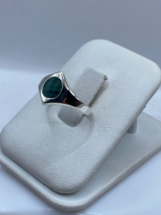 Anillo solitario malaquita en mano de mujer, mostrando vetas naturales verdes