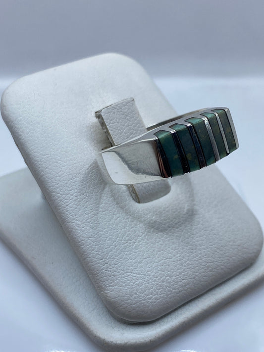 Anillo eslabón arquitectónico de plata en la mano, mostrando peso y presencia