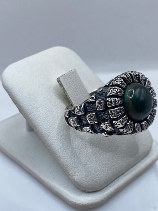 Detalle de la malaquita verde natural con vetas en anillo de plata