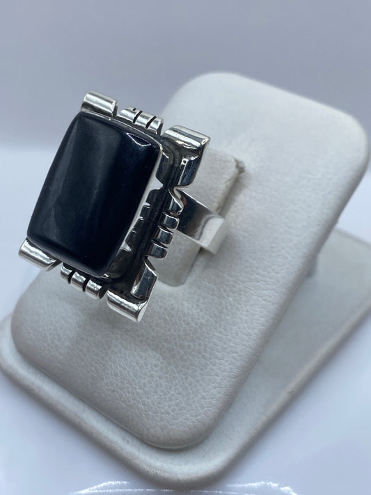 Detalle lateral del anillo mostrando el engaste a mano del onix y las líneas geométricas de plata