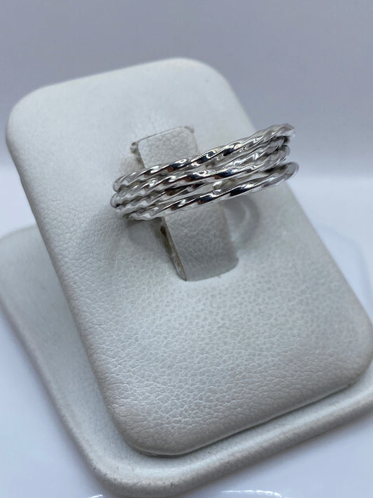 Detalle lateral del anillo mostrando las bandas trenzadas y el pulido brillante