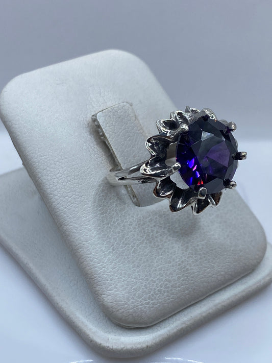 Anillo vintage de circonia morada en dedo, luz natural mostrando el brillo