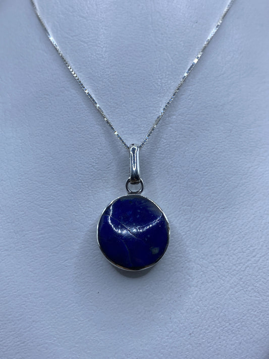 Detalle del dije de 3.3 cm mostrando la piedra azul engastada en plata