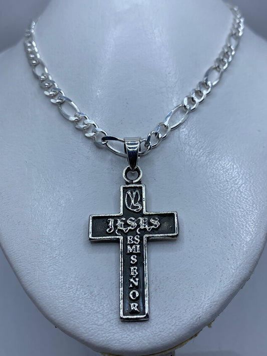 Vista frontal de la cruz de plata, diseño religioso con letras grabadas