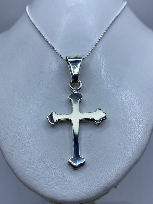 Cruz de plata Taxco con Quinto 925 colgada en collar sobre pecho