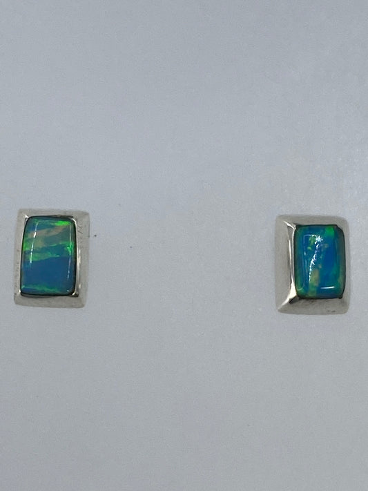 Detalle del engaste a mano del ópalo de fuego en plata, vista frontal de un arete