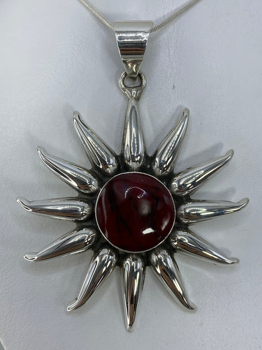 Vista de frente del dije sol radiante en plata pulida, 6.4 cm de largo