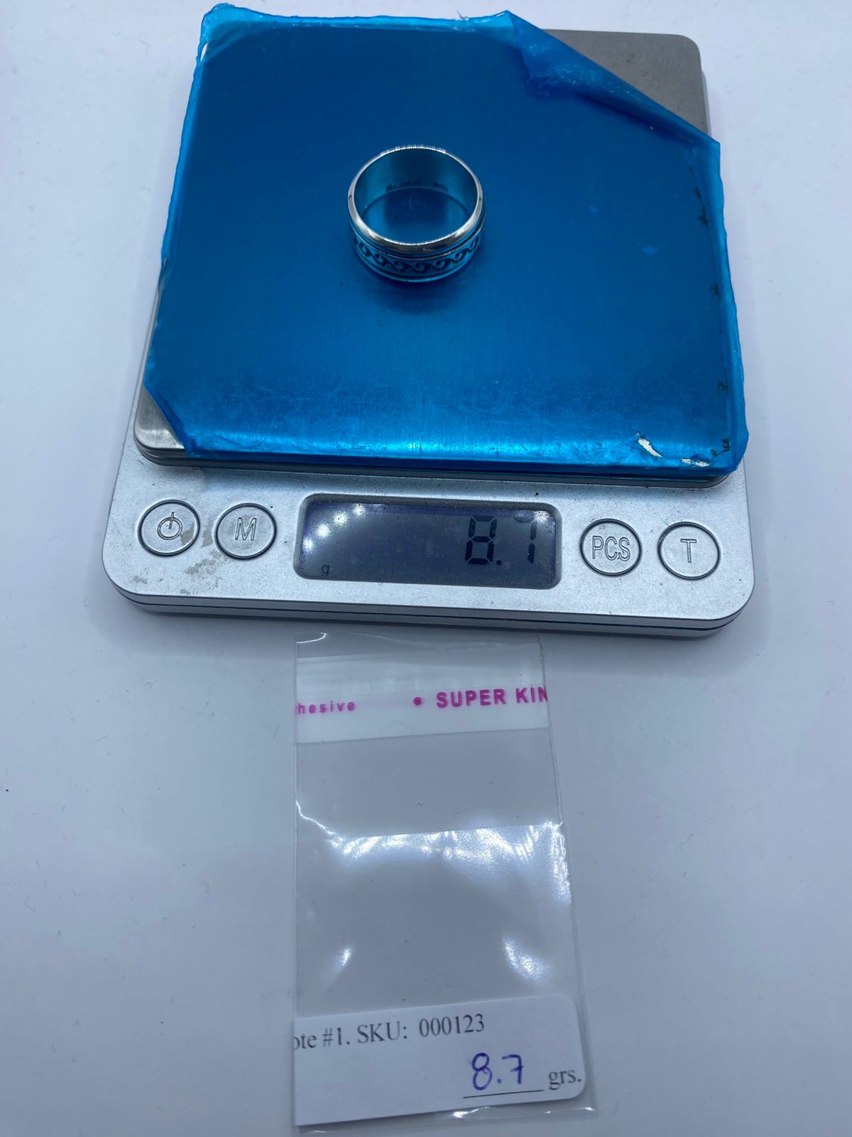 Anillo de plata .925 con volutas ola y mecanismo giratorio sobre superficie — joyería mexicana antiestrés artesanal Taxco