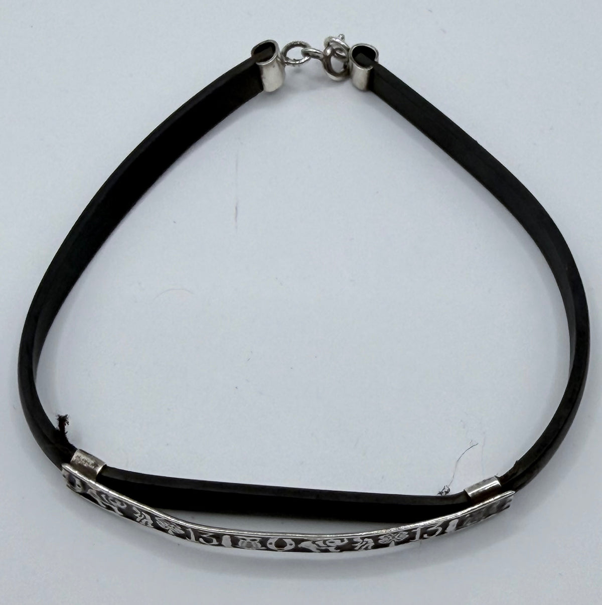 Detalle de cierre elástico plateado y grabados de la buena suerte en pulsera de Taxco