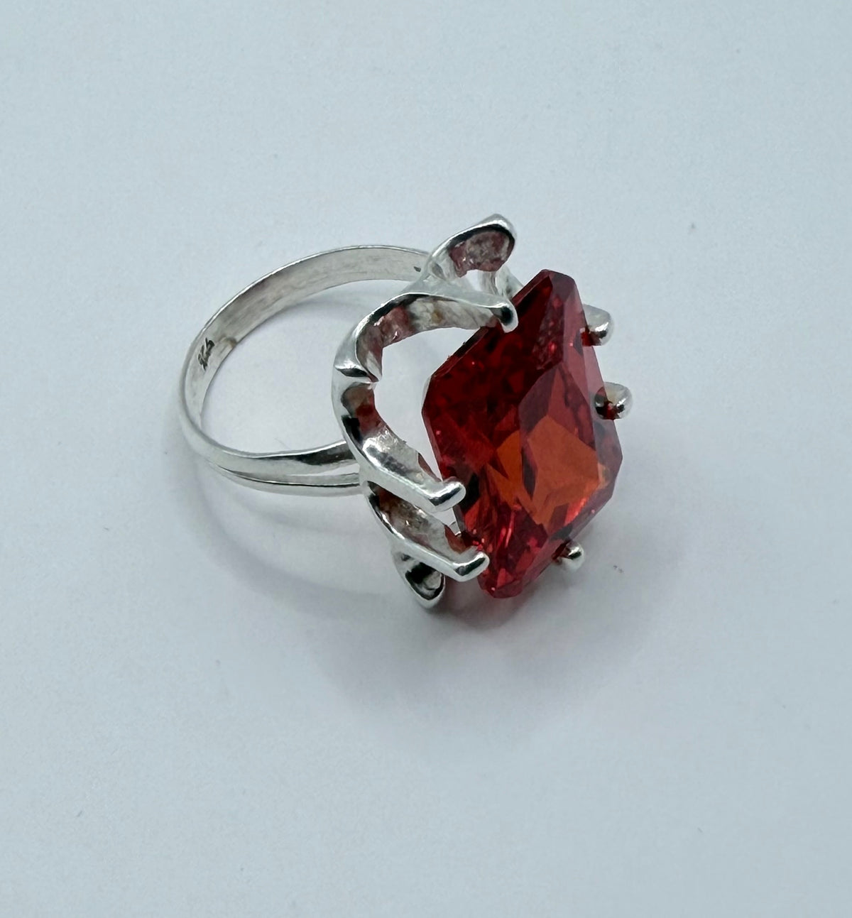 Vista frontal del anillo circonia roja con brillo intenso y facetas cristalinas visibles