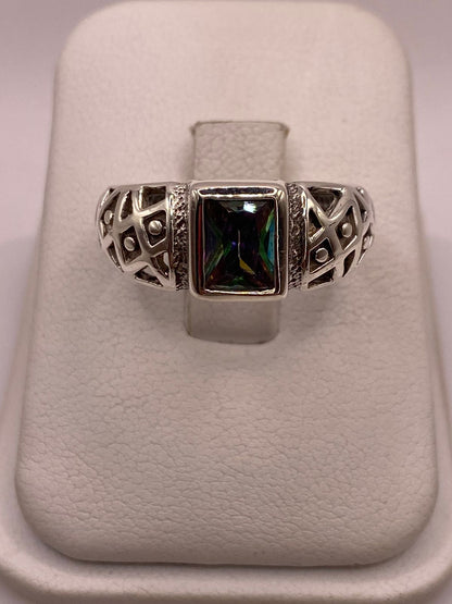 Anillo solitario de plata .950 con circonia rectangular multicolor y calado geométrico sobre fondo neutro — artesanal Taxco