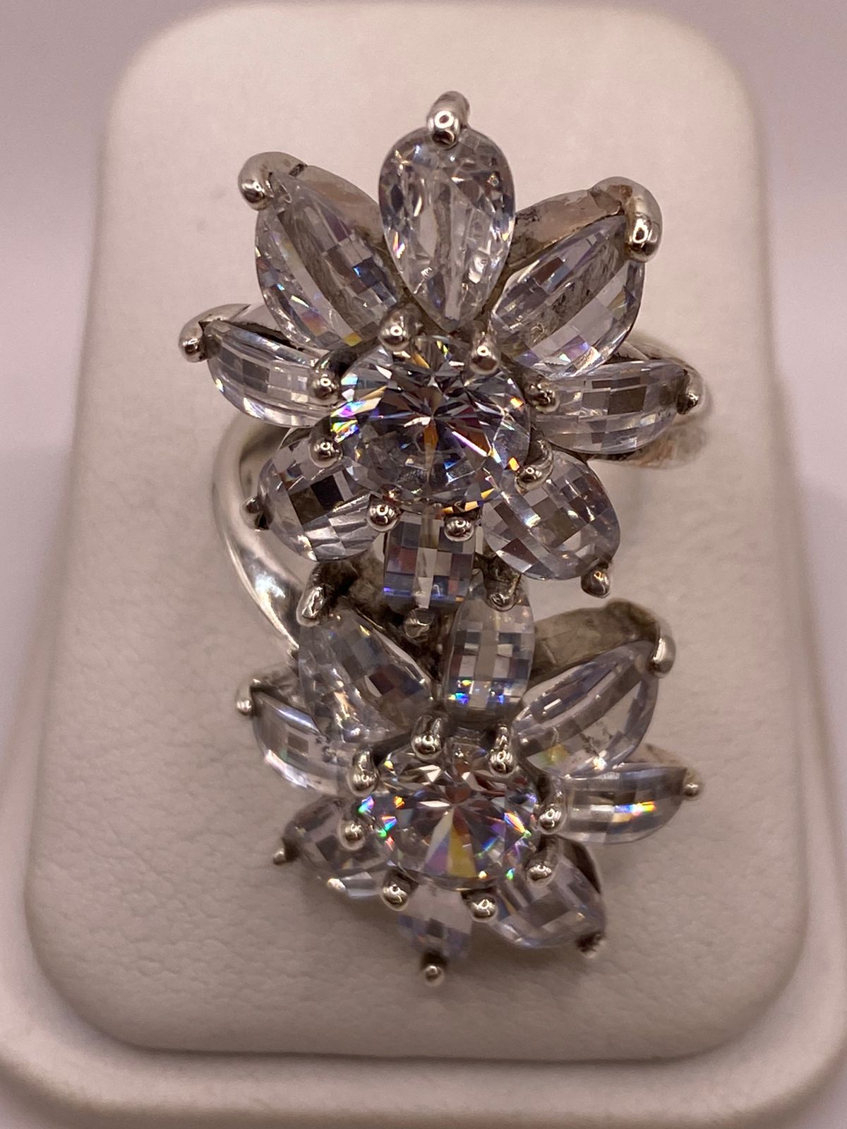 Anillo doble flor de plata 925 con zirconias en corte gota sobre fondo neutro, Arte Taxco