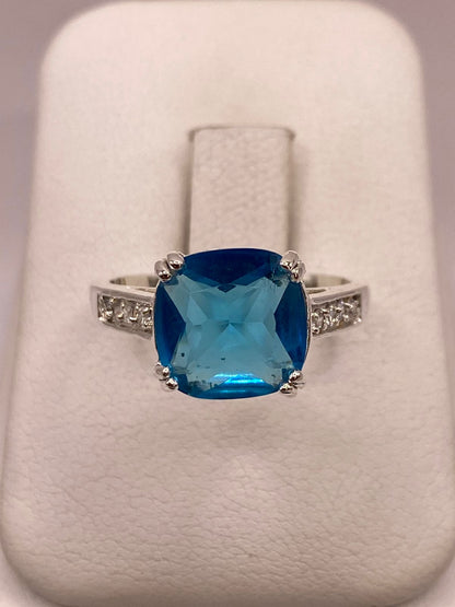 Anillo de Plata Ley 925 con Zirconia Azul Corte Cojín Diseño Clásico Elegante en báscula mostrando peso