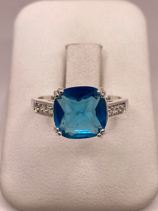 Anillo de Plata Ley 925 con Zirconia Azul Corte Cojín Diseño Clásico Elegante en báscula mostrando peso