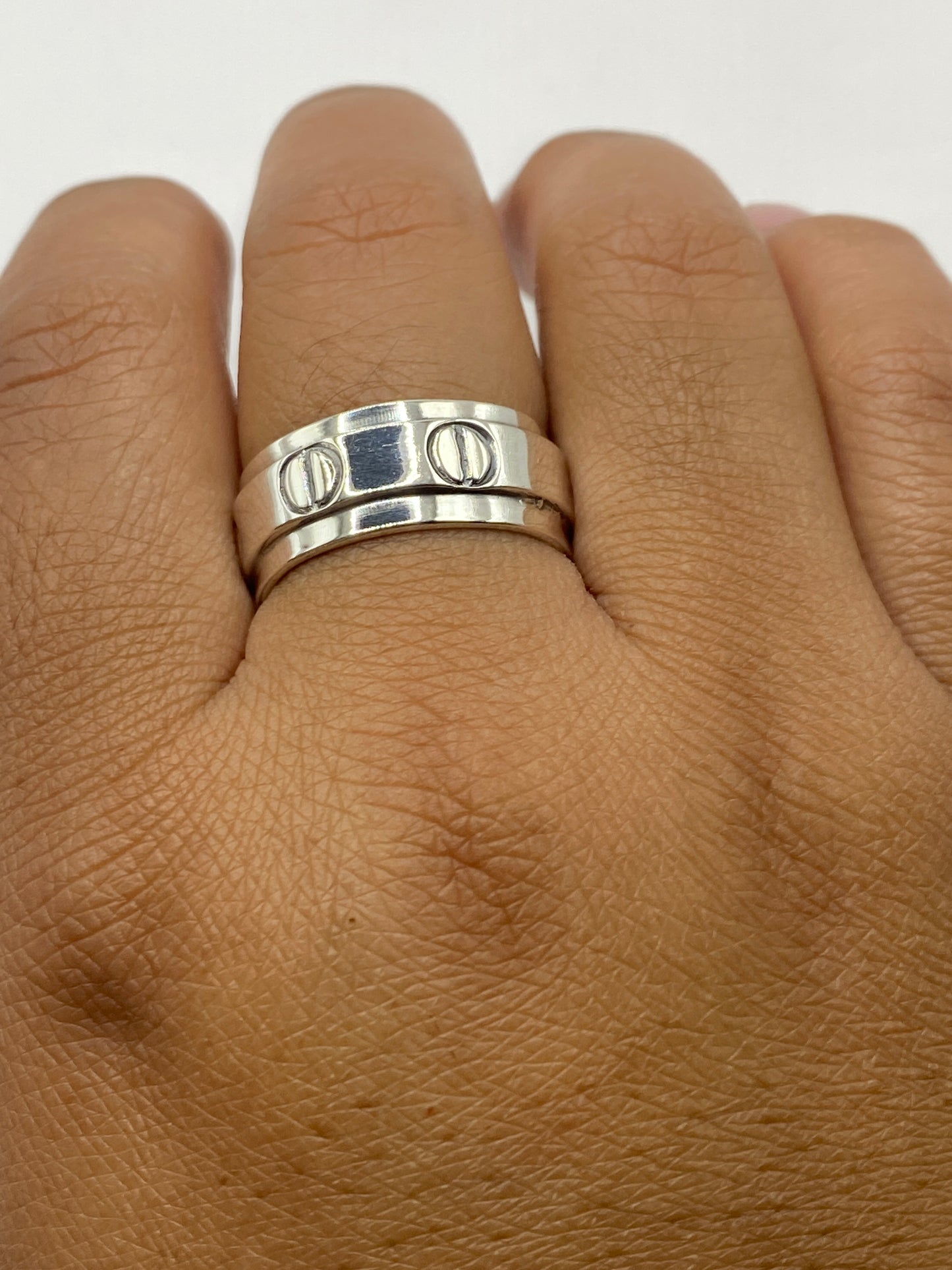 Anillo de plata sobre superficie gris mostrando el sello .925 MEXICO en el interior de la banda