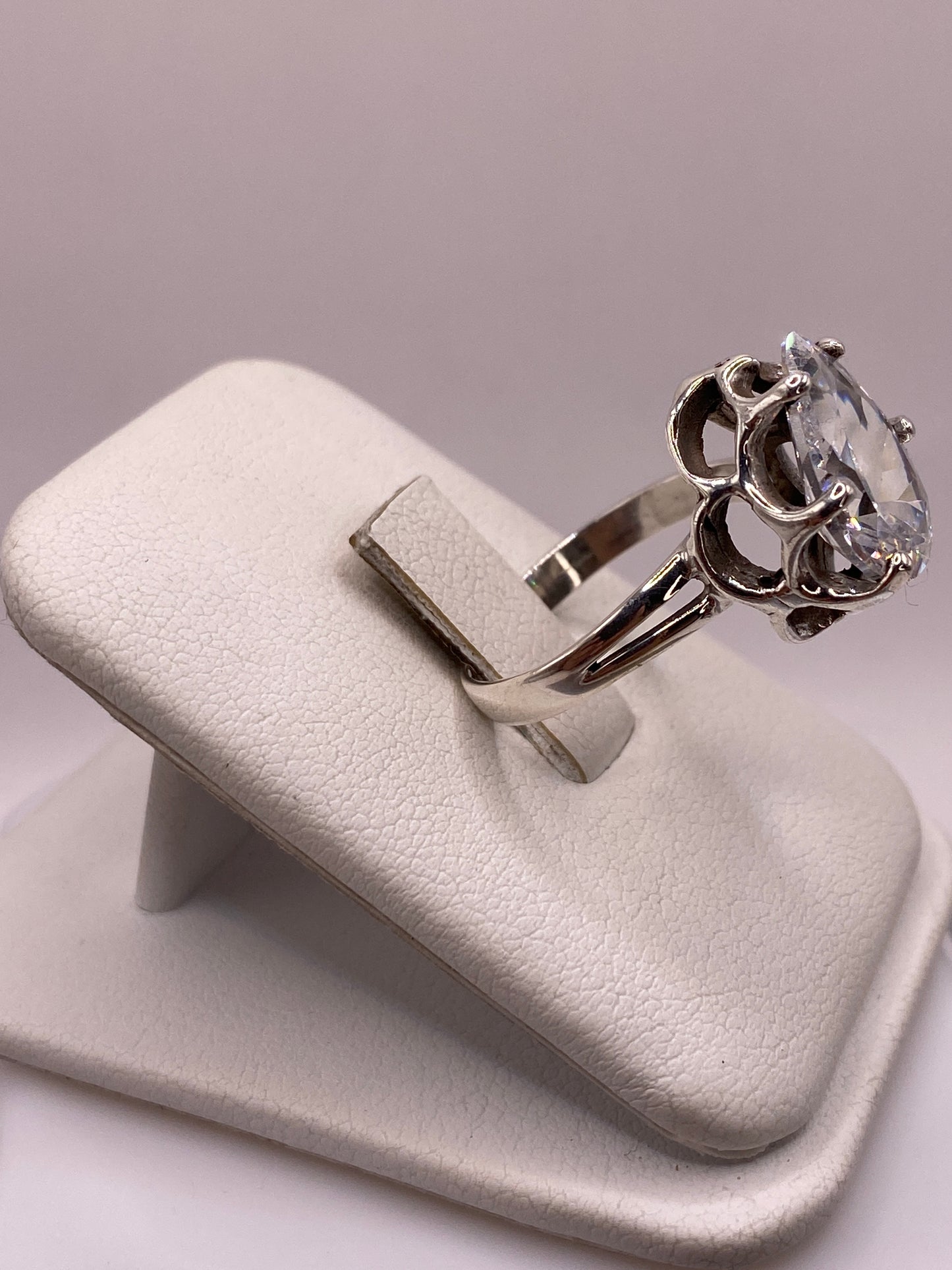 Anillo plata solitario con piedra blanca brillante, detalle lateral mostrando el engaste