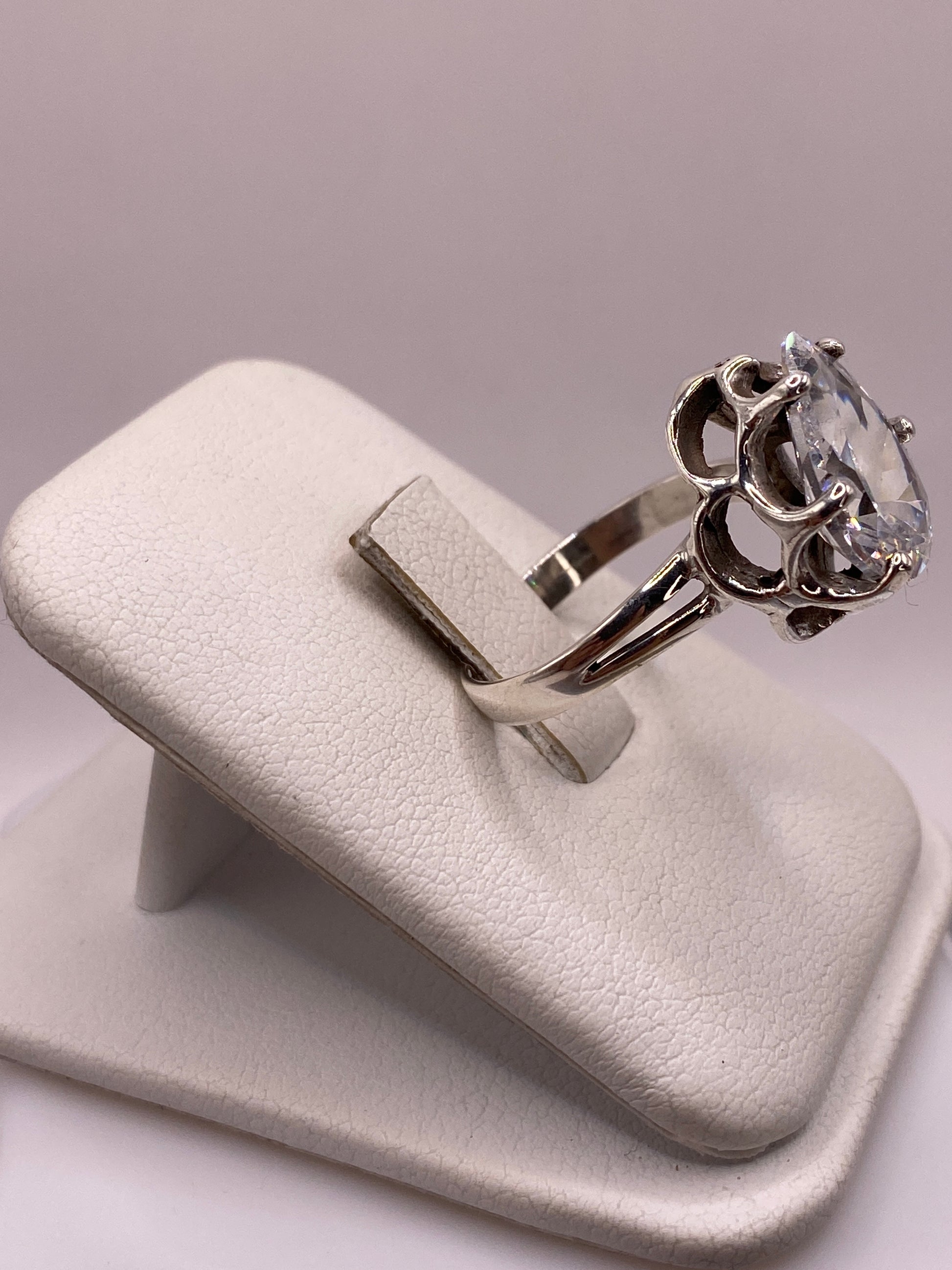 Anillo plata solitario con piedra blanca brillante, detalle lateral mostrando el engaste