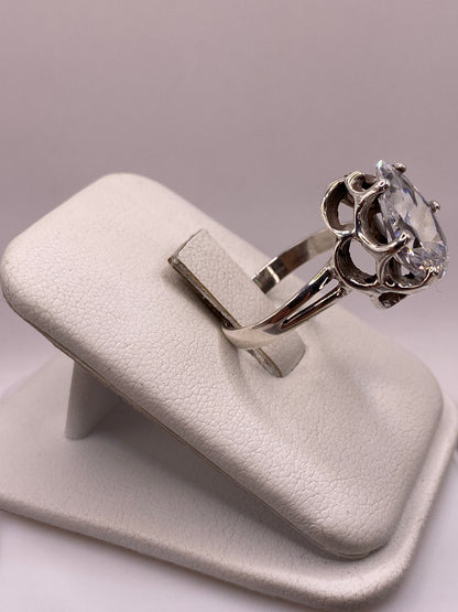 Anillo plata solitario con piedra blanca brillante, detalle lateral mostrando el engaste