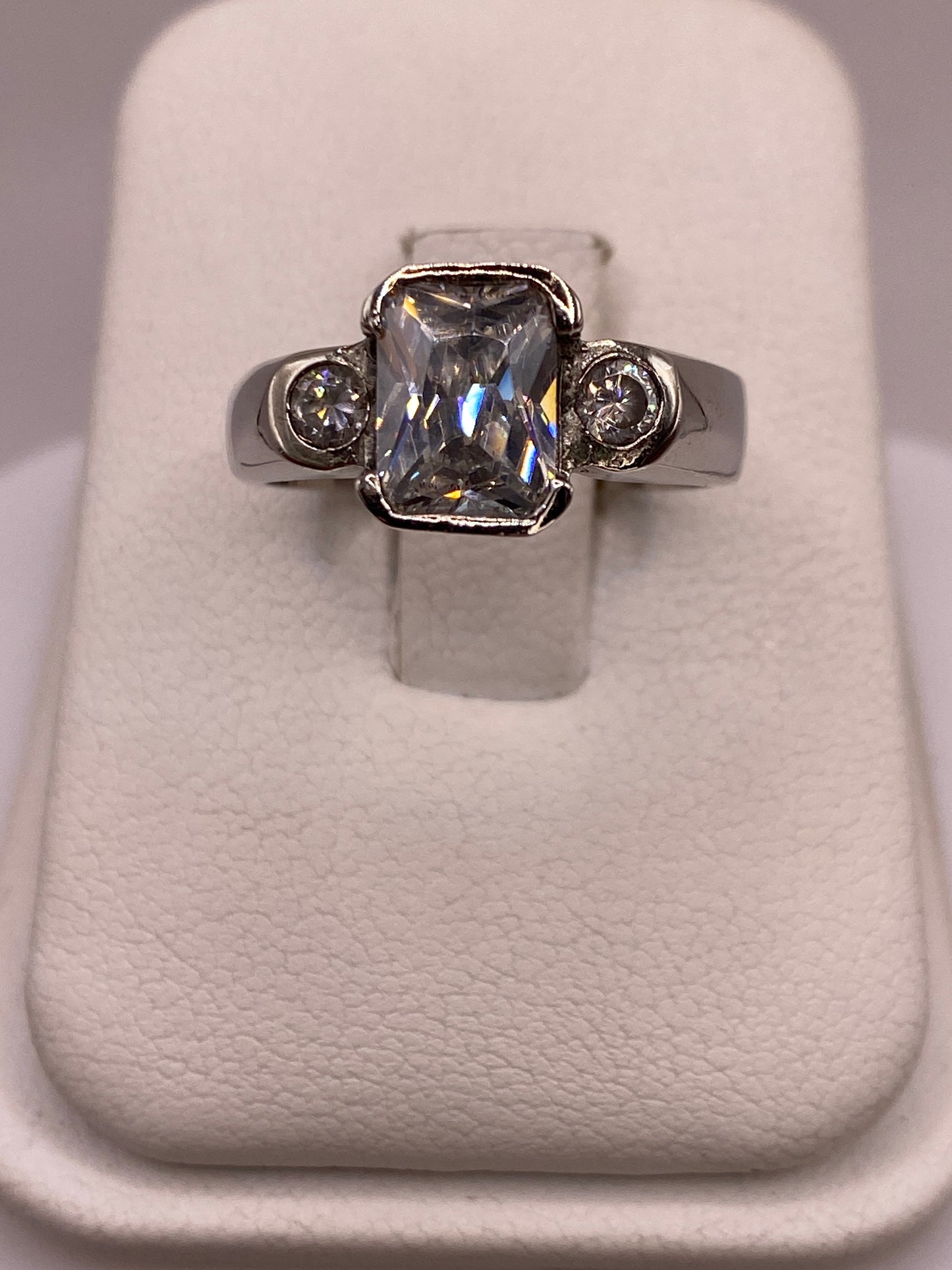 Anillo solitario de plata con circonia blanca facetada, frente a la mano