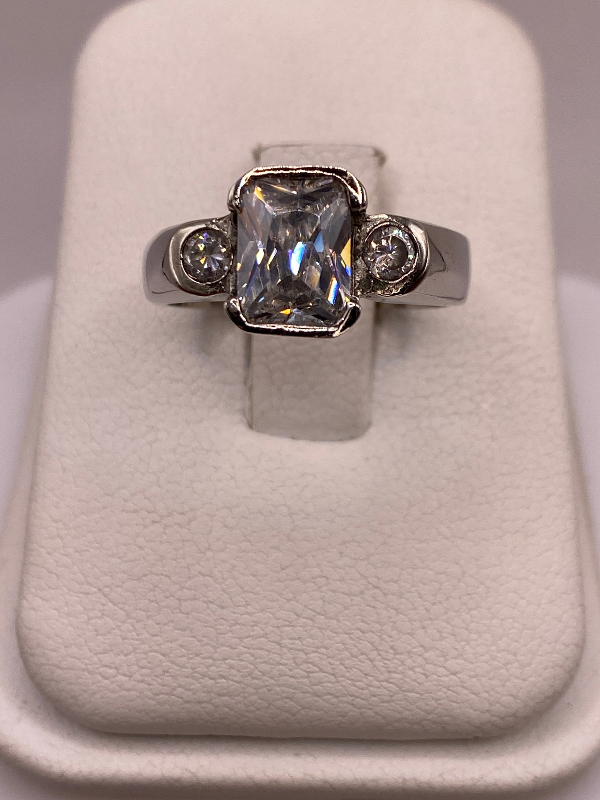 Anillo solitario de plata con circonia blanca facetada, frente a la mano