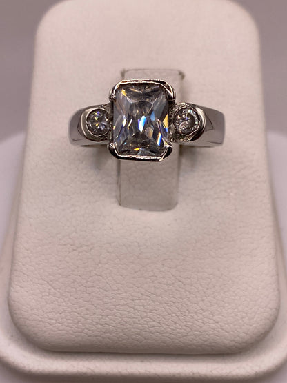 Anillo solitario de plata con circonia blanca facetada, frente a la mano