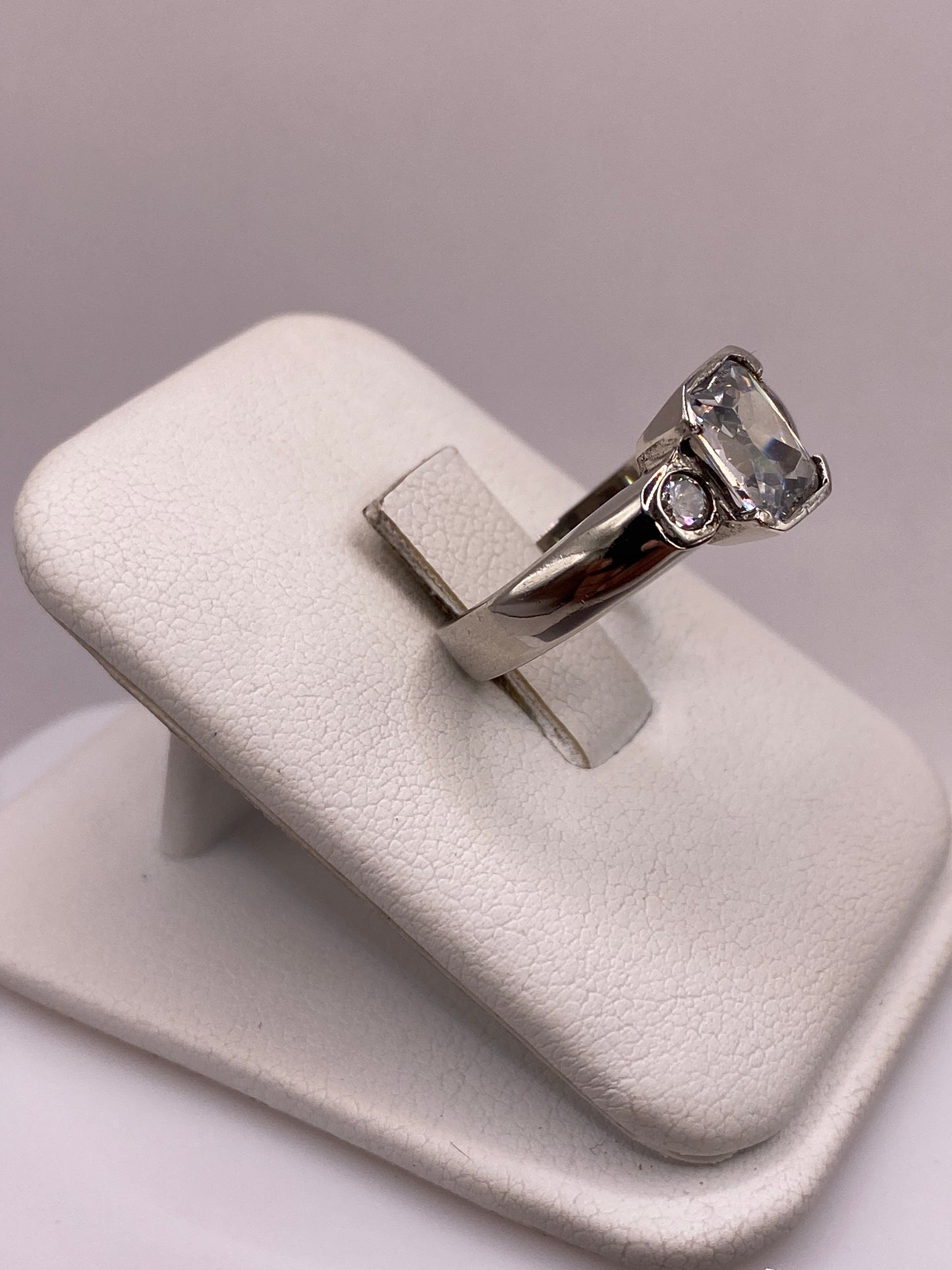 Detalle lateral del anillo mostrando la banda gruesa y el engaste de la circonia