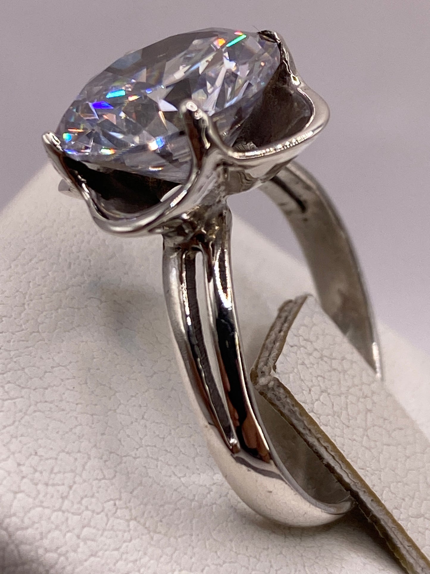 Anillo solitario circonia en la mano de una mujer, brillo diamantado bajo luz natural