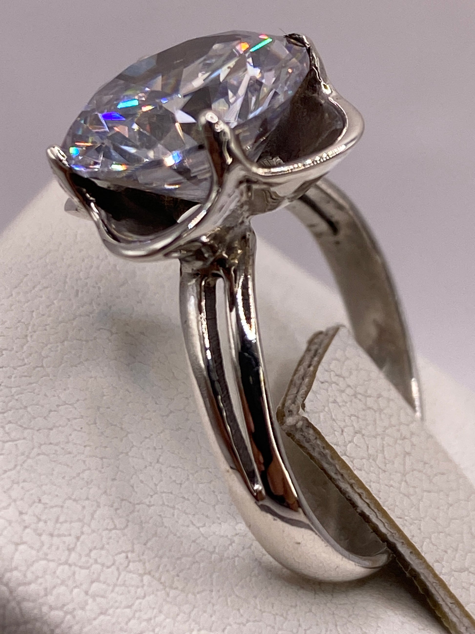 Anillo solitario circonia en la mano de una mujer, brillo diamantado bajo luz natural
