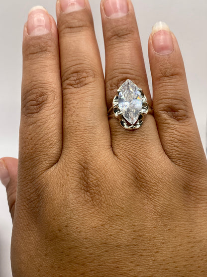 Anillo solitario marqués en la mano mostrando el sello .925 MEXICO