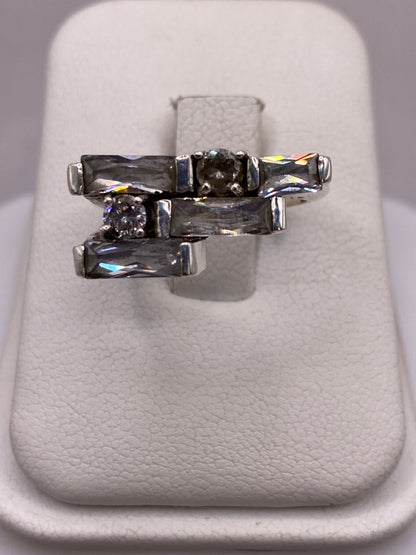 Anillo de plata arquitectónico con circonias blancas y grises, vista superior sobre fondo blanco
