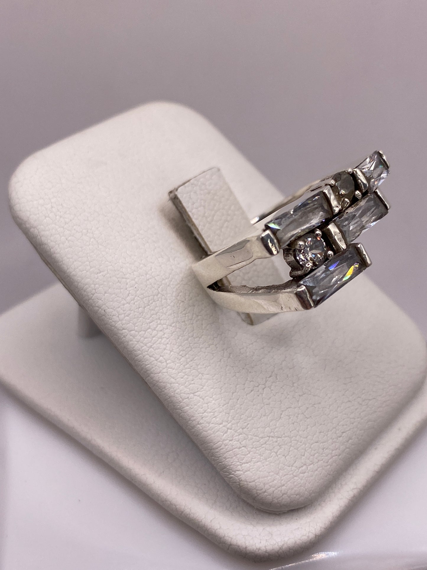 Anillo unisex de plata .925 con estructura escalonada en mano, mostrando engaste de circonia