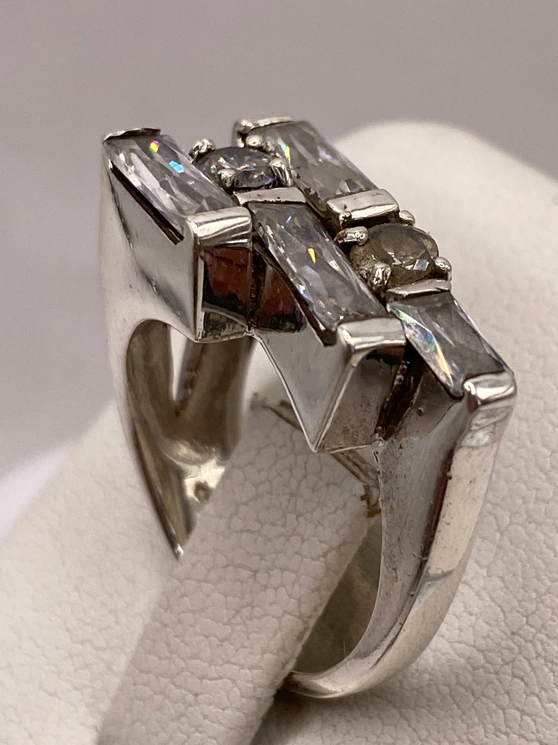 Detalle lateral del anillo de plata con diseño en capas y brillo de circonia