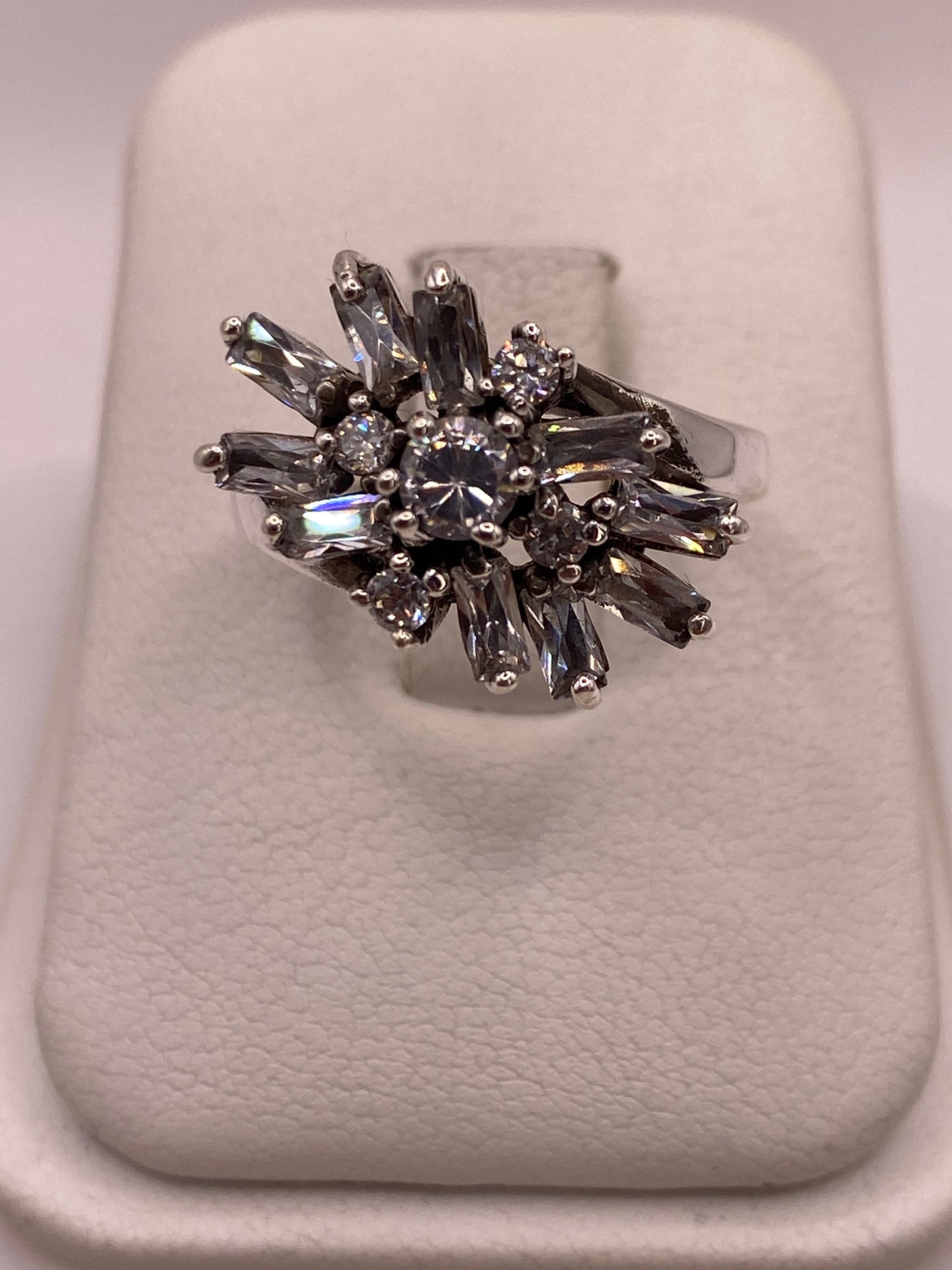 Anillo coctel de plata .925 con explosión de circonias baguette y redondas blancas sobre display blanco