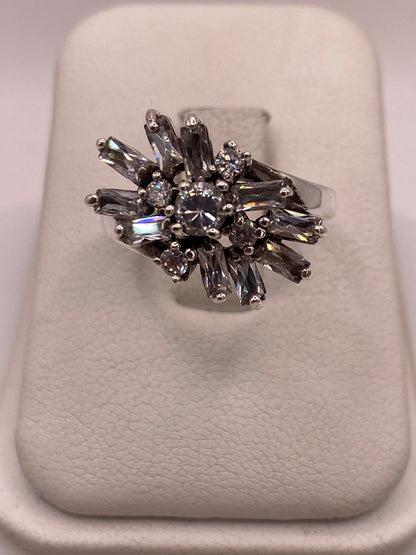 Anillo coctel de plata .925 con explosión de circonias baguette y redondas blancas sobre display blanco