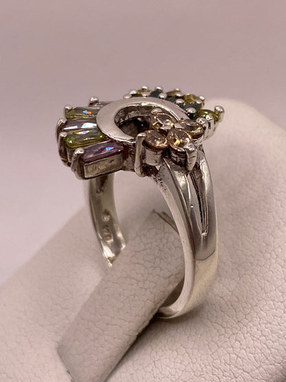 Detalle del engaste en garras del anillo de plata luna creciente con baguettes lila y verde y sello 925 en la banda