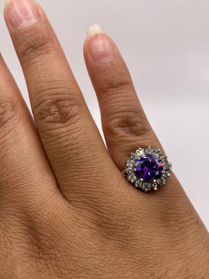 Anillo halo de circonia morada en plata .925 puesto en la mano de una mujer, talla 6