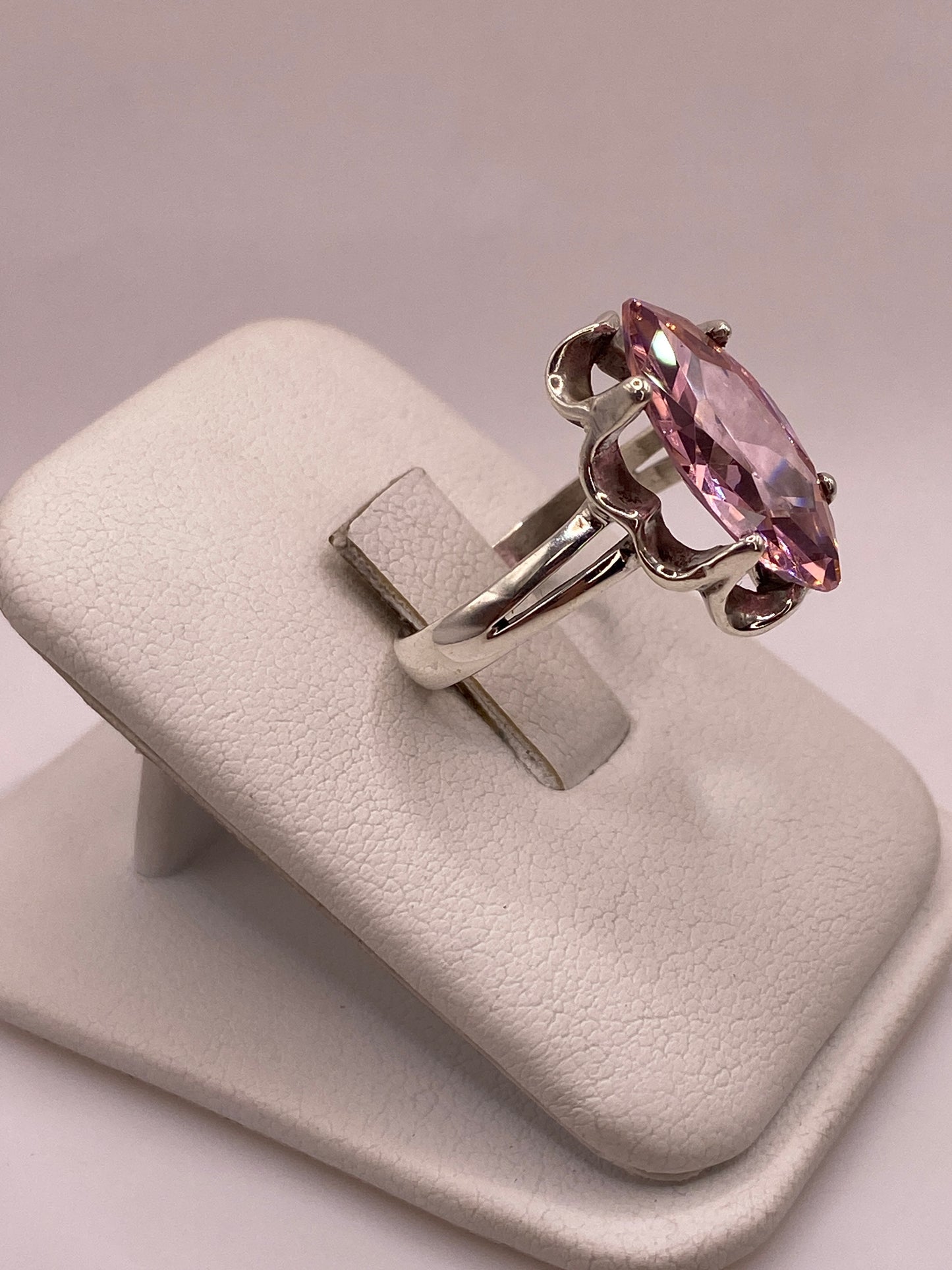 Vista lateral del anillo solitario marquesa rosa en plata, mostrando montura festoneada y banda doble