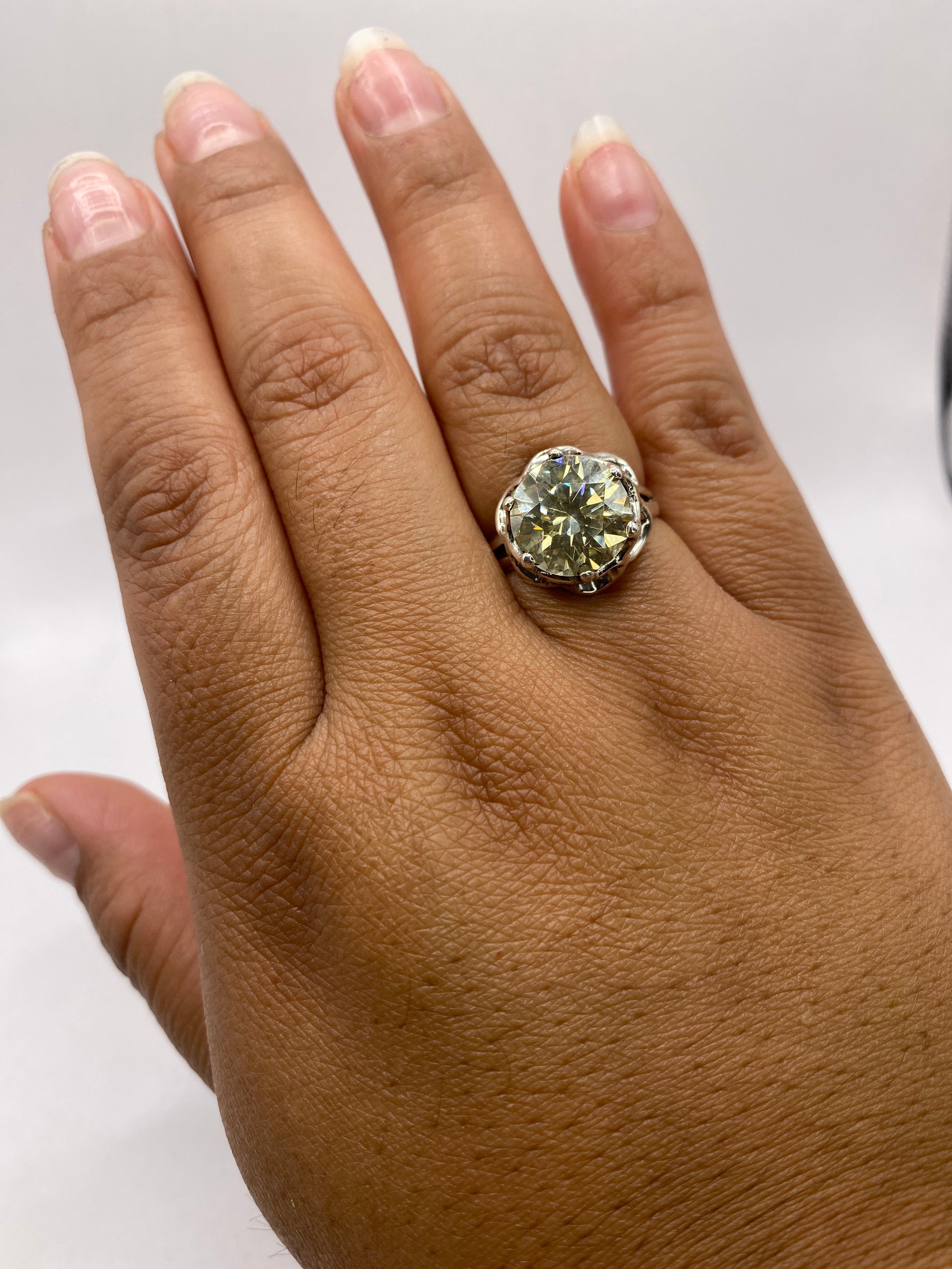 Anillo solitario de plata con circonia champán puesto en la mano de una mujer, mostrando el tamaño real de la piedra